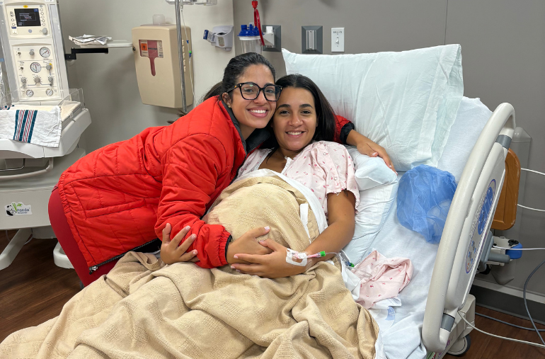 A doula embracing an expectant mother in her hospital bed
